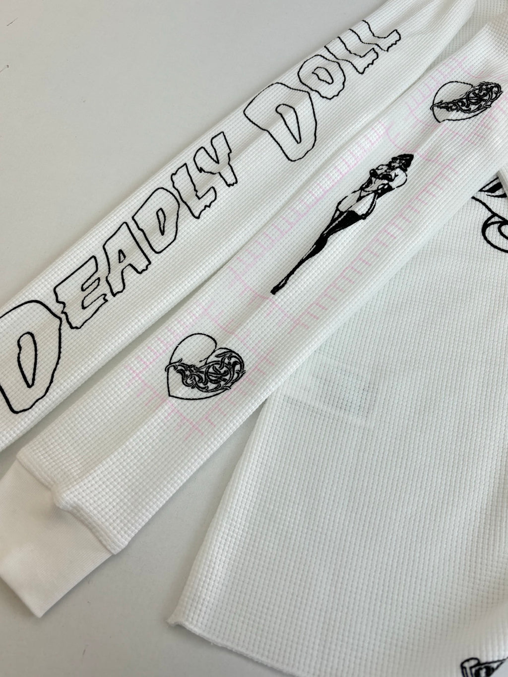 White sleeve cuff with black text and small icon prints