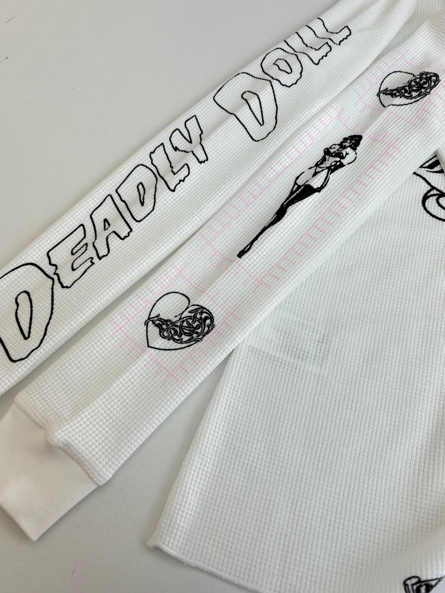 White sleeve cuff with black text and small icon prints