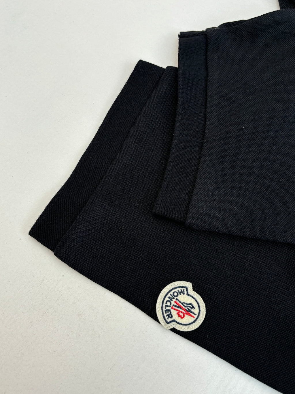 Moncler polo shirt side view, dark navy with small circular logo patch
