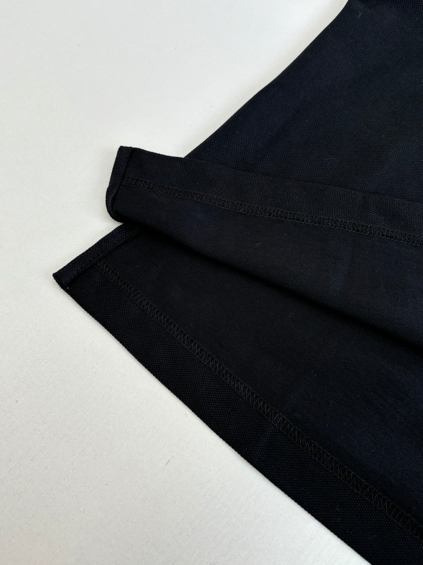 Moncler polo shirt sleeve hem detail in dark navy with neat stitched cuff