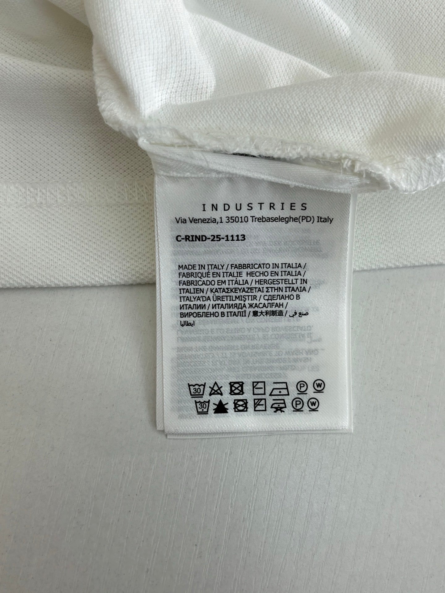 White polo shirt care label with fabric and washing symbols