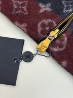 Monogram jacket zipper pull in gold with attached tag and keychain charm.