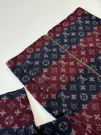 Maroon and navy monogram zip jacket with gold zipper line, collar visible.