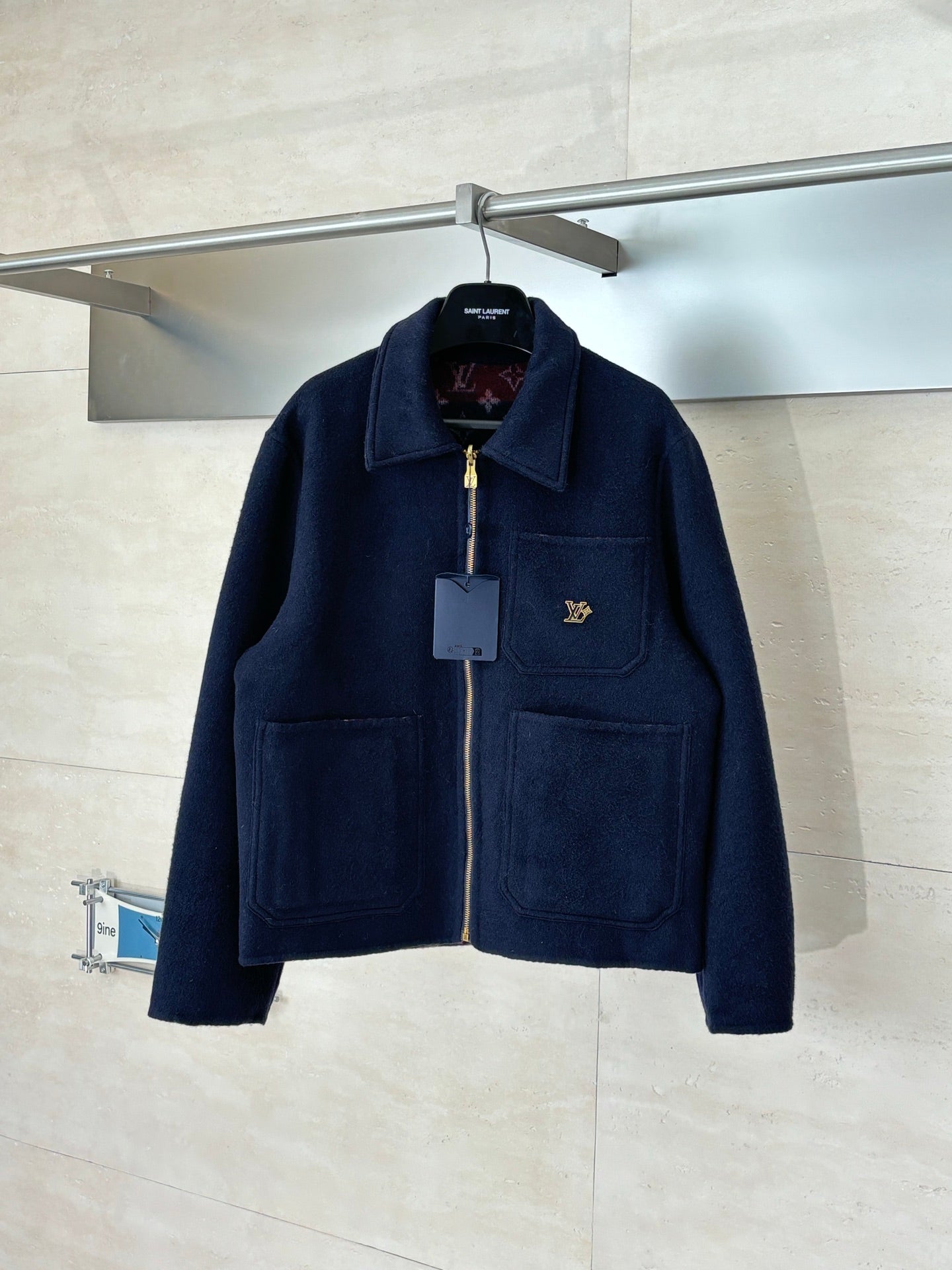 Long Louis Vuitton zip-up jacket in dark navy with stand collar, pockets, and gold logo.