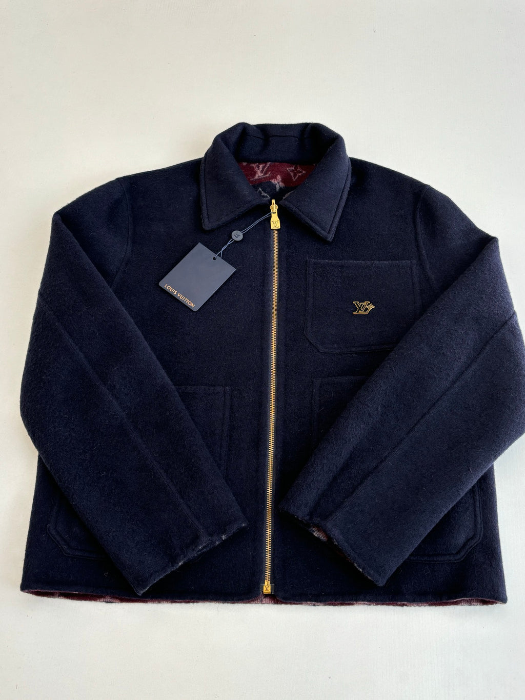 Monogram-free Louis Vuitton dark navy zip jacket with stand collar, tag, and gold zipper.