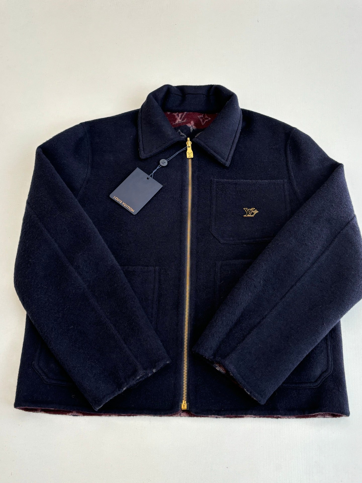 Monogram-free Louis Vuitton dark navy zip jacket with stand collar, tag, and gold zipper.