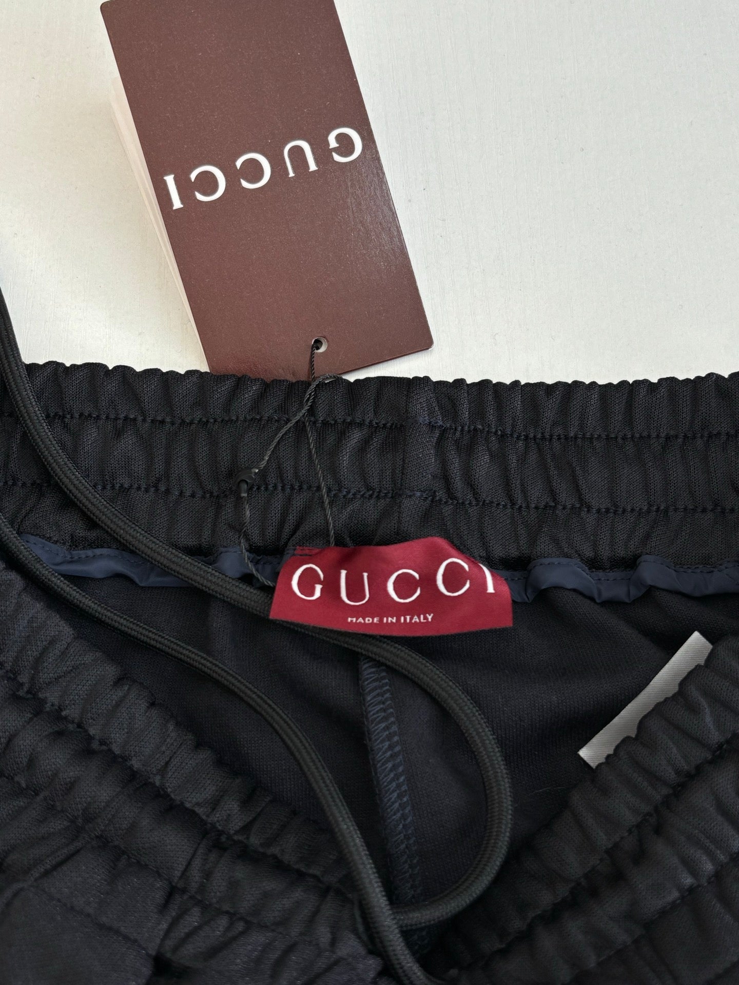 Navy track pants close-up of elastic waistband and Gucci logo label