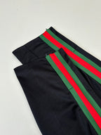 Black track pants with green and red diagonal stripe accents