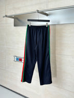 Navy drawstring pants with elastic waist and green, red side stripe accents