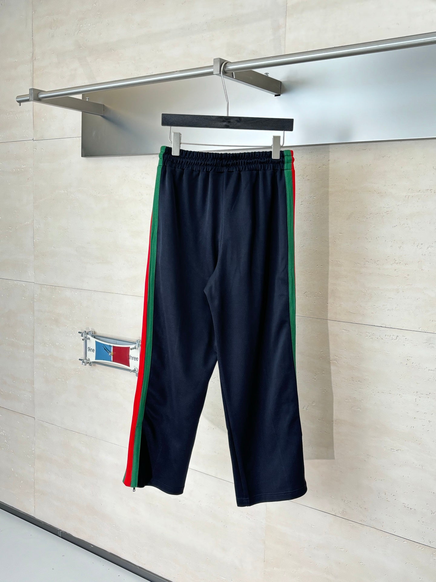 Navy drawstring pants with elastic waist and green, red side stripe accents