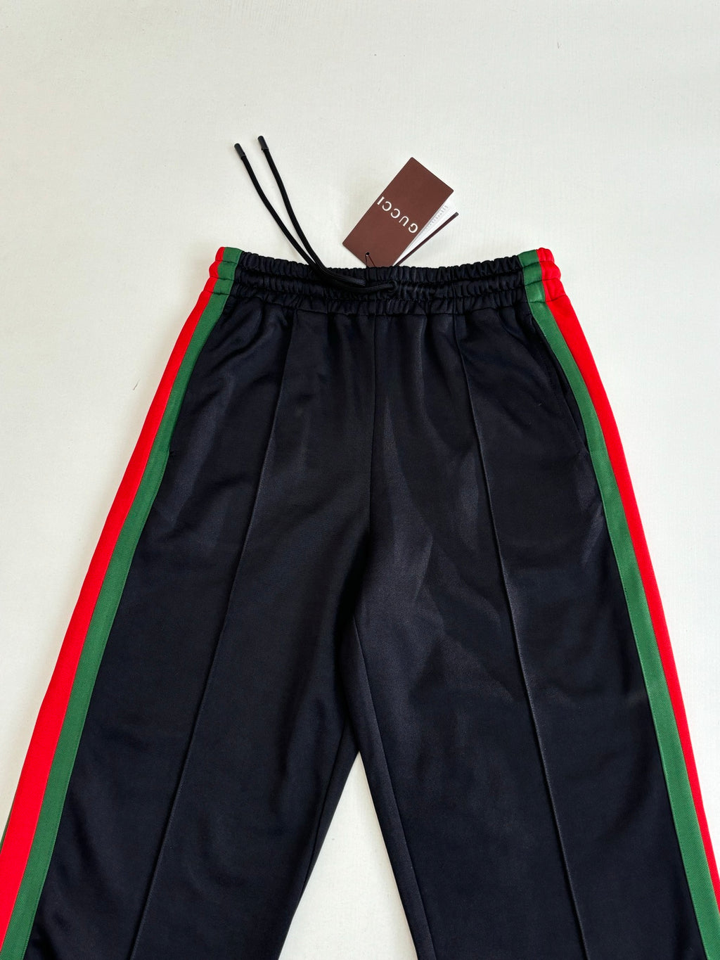 Navy track pants with elastic waistband and green-and-red side stripe