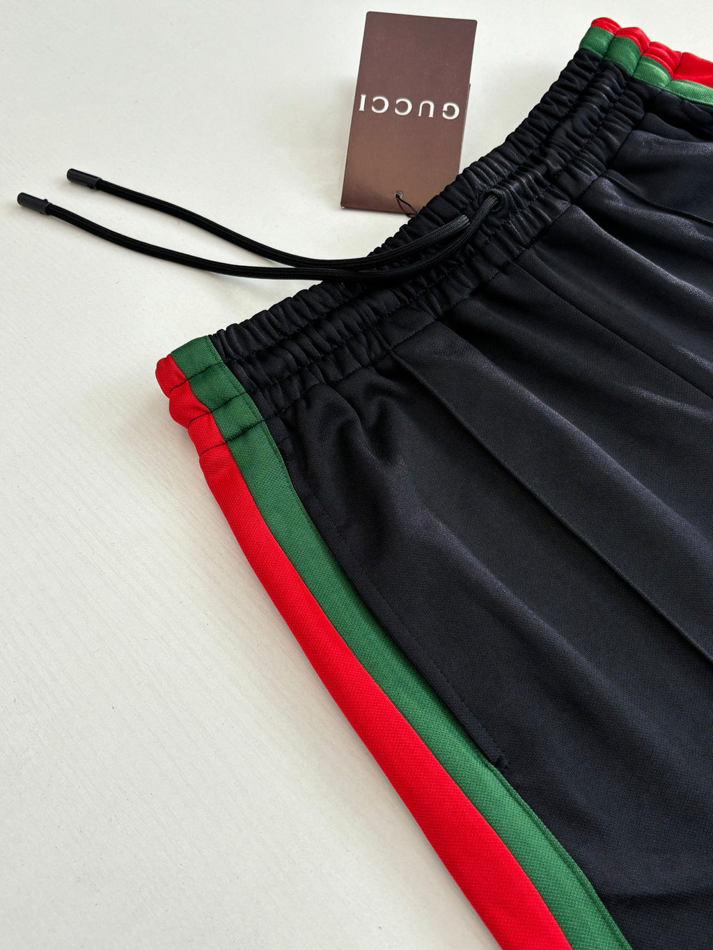 Navy track pants with elastic drawstring waistband and green-red side stripe