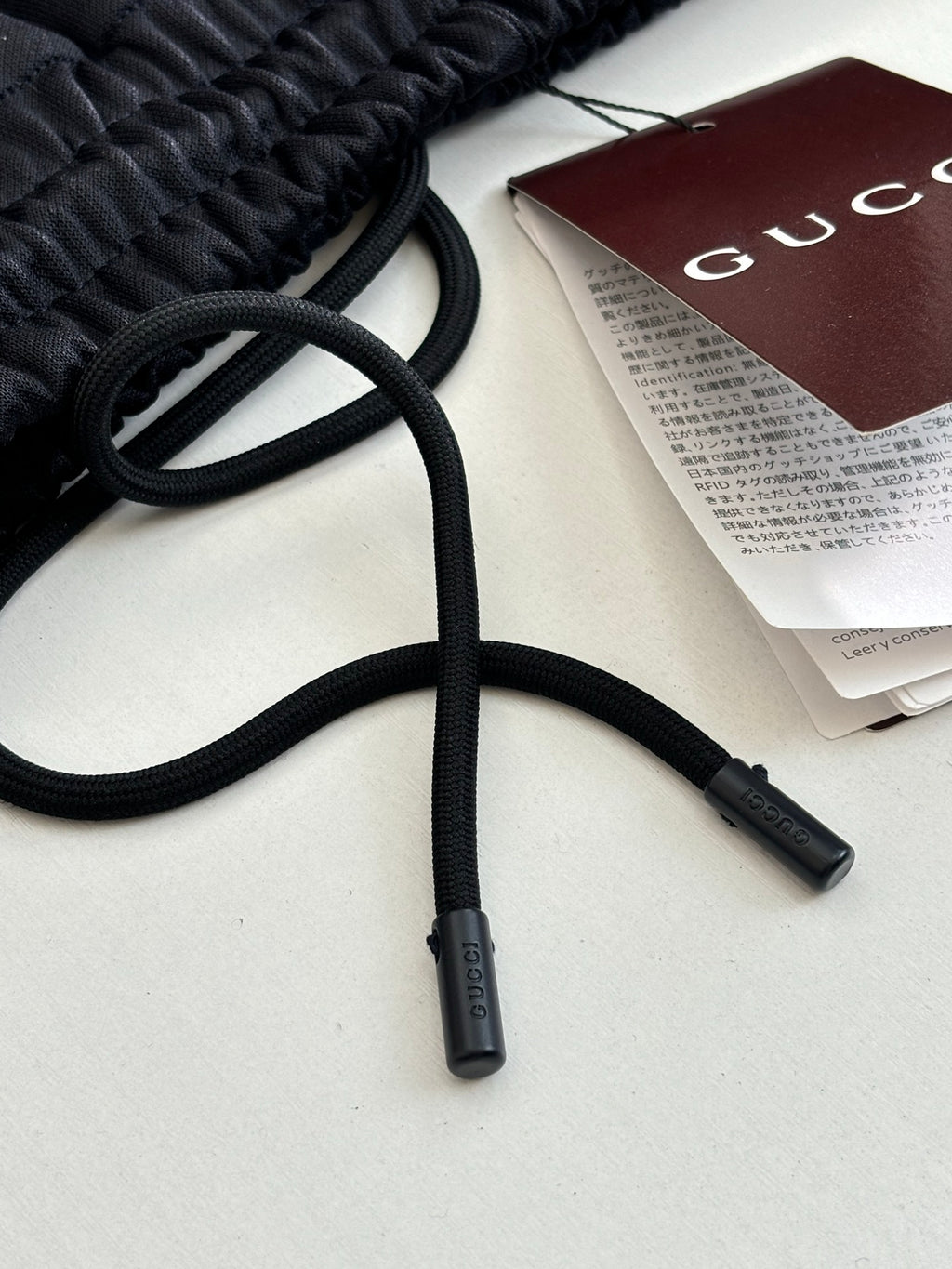 Navy track pants drawstrings with Gucci hang tag