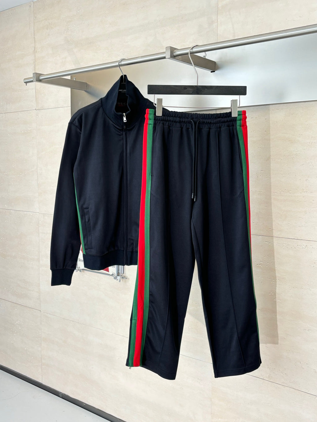 Navy track pants with elastic waist, drawstring, and green-red side stripes