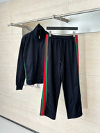 Navy track pants with elastic waist, drawstring, and green-red side stripes