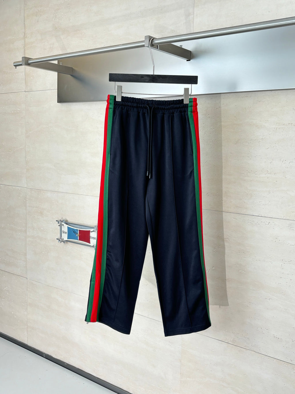 Navy track pants with elastic waistband and green-red side stripes