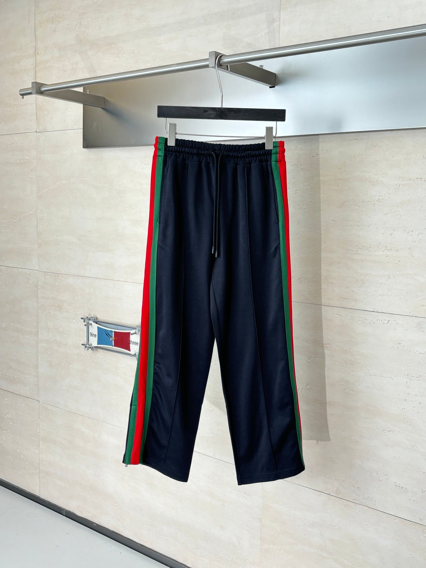 Navy track pants with elastic waistband and green-red side stripes
