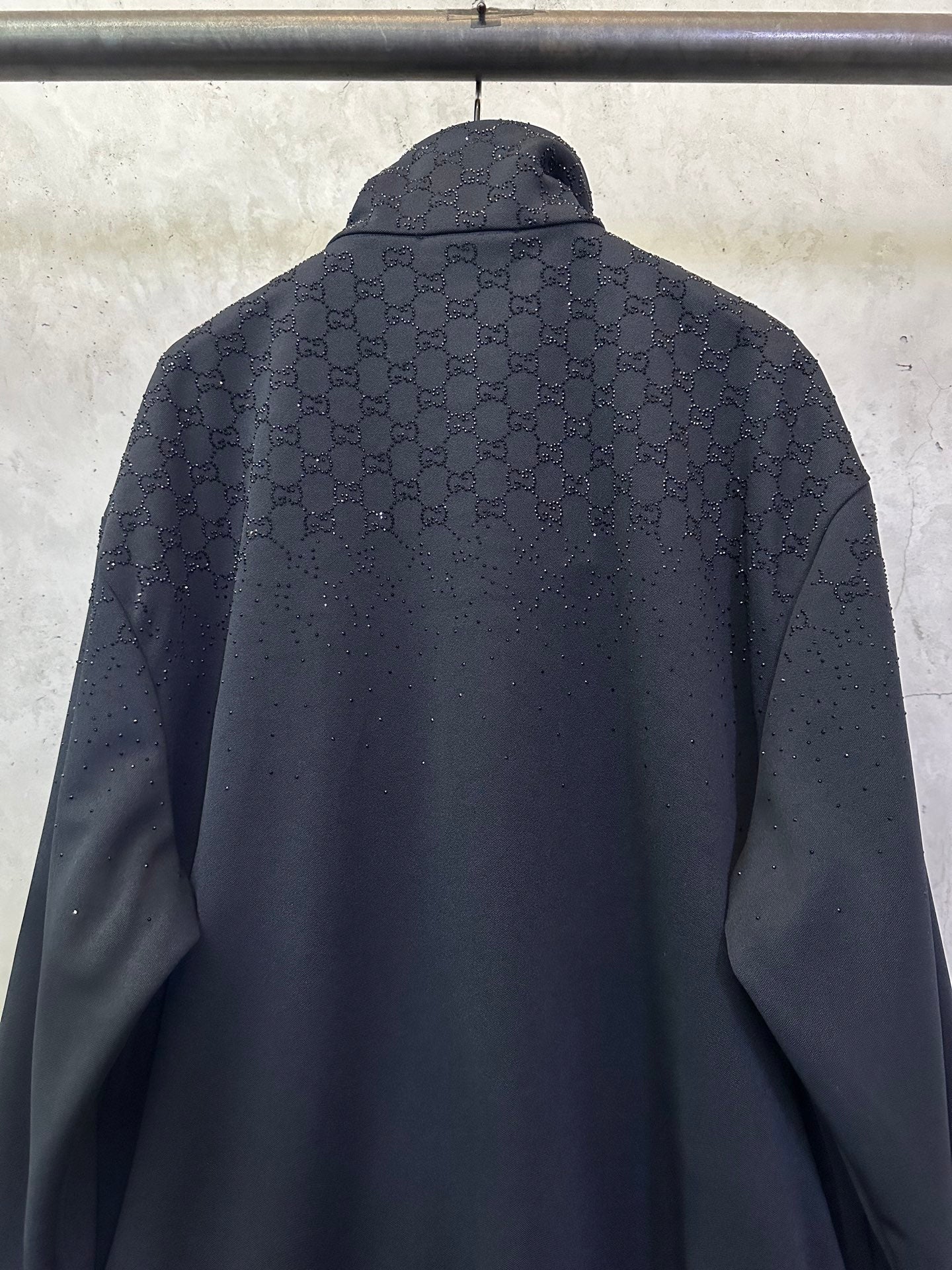 Dark Gucci zip-up jacket back with monogram pattern and stand collar