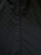 Dark Gucci monogram zip-up jacket fabric detail with stitched zipper front