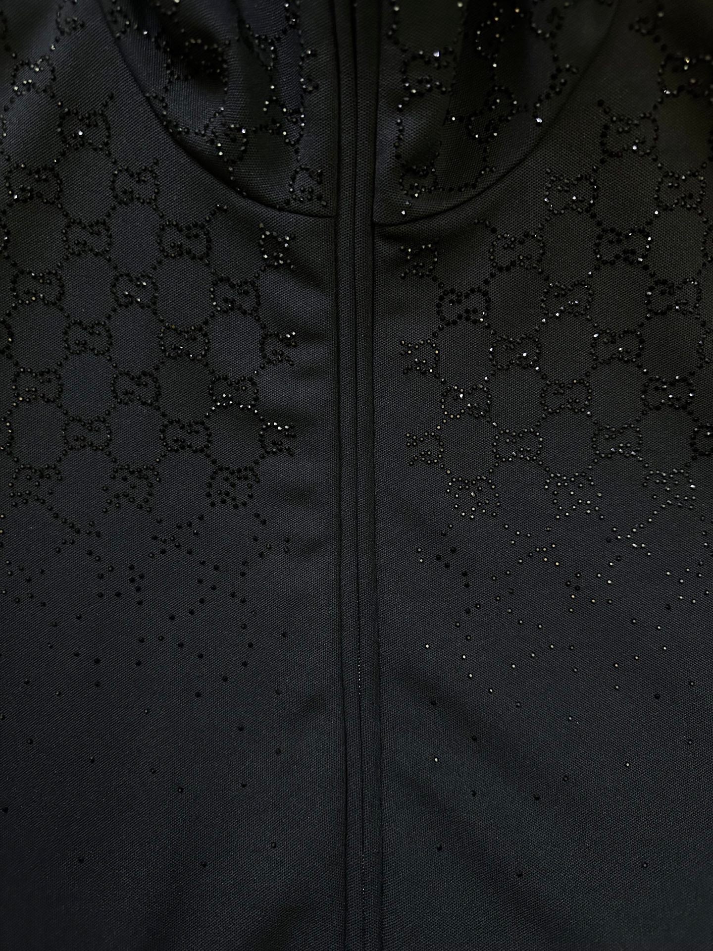 Dark Gucci monogram zip-up jacket fabric detail with stitched zipper front