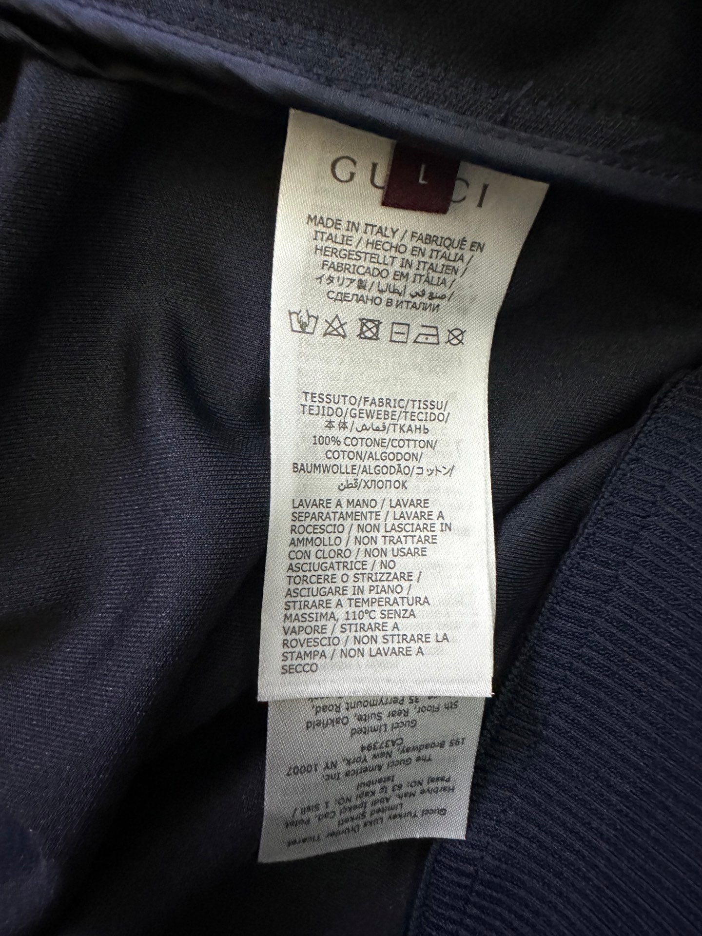 Gucci care label tag inside dark zip-up jacket