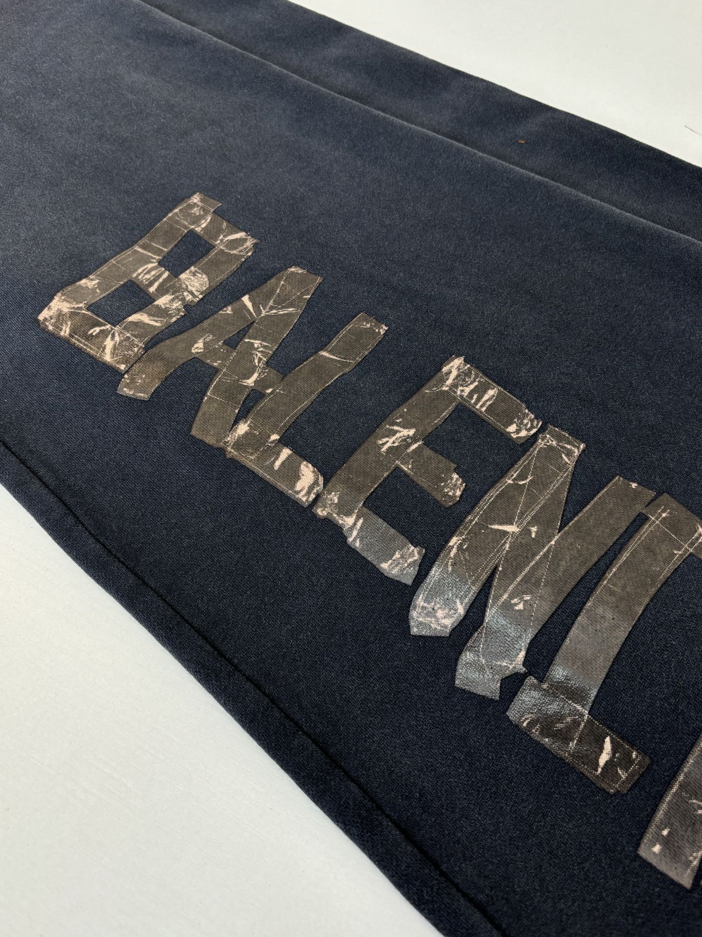 Balenciaga dark navy sweatpants leg with metallic logo lettering across front