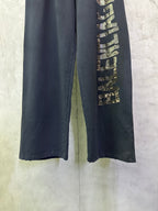 Close-up of dark blue pants leg with vertical gold-toned graphic detailing