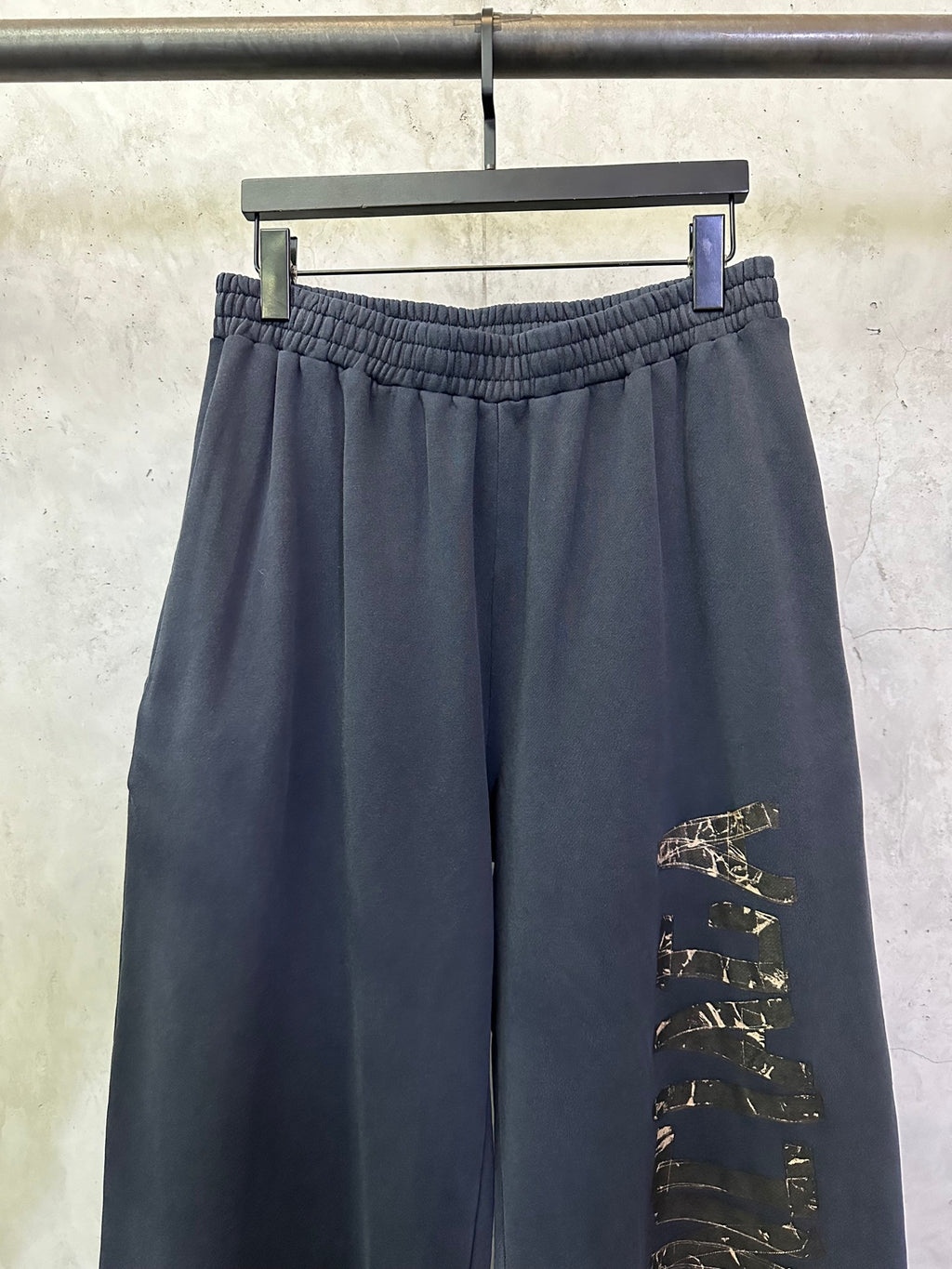 Dark blue pants with elastic waistband and vertical side graphic panel