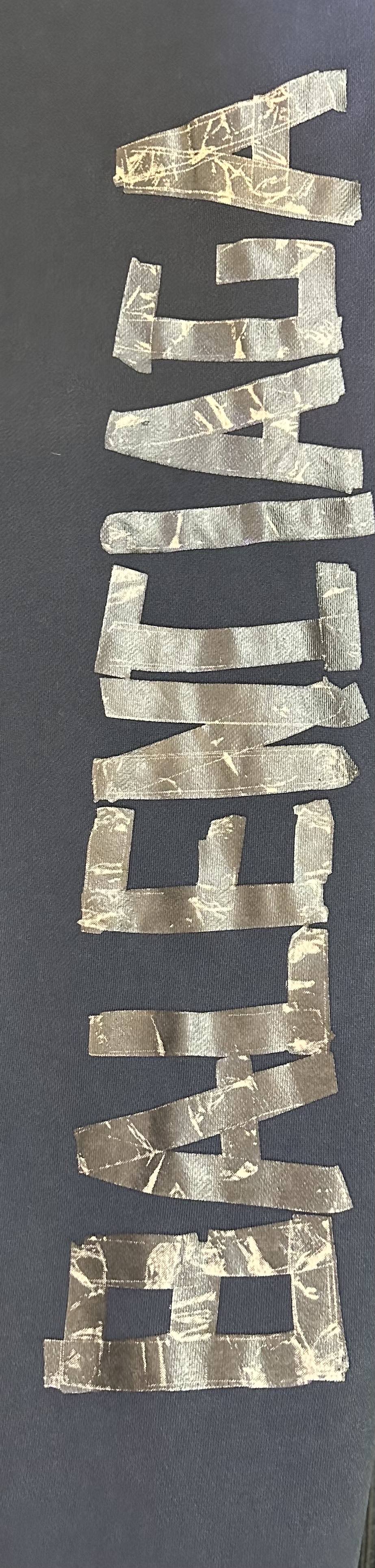 Dark blue pants with large vertical gold-toned graphic detail on the side