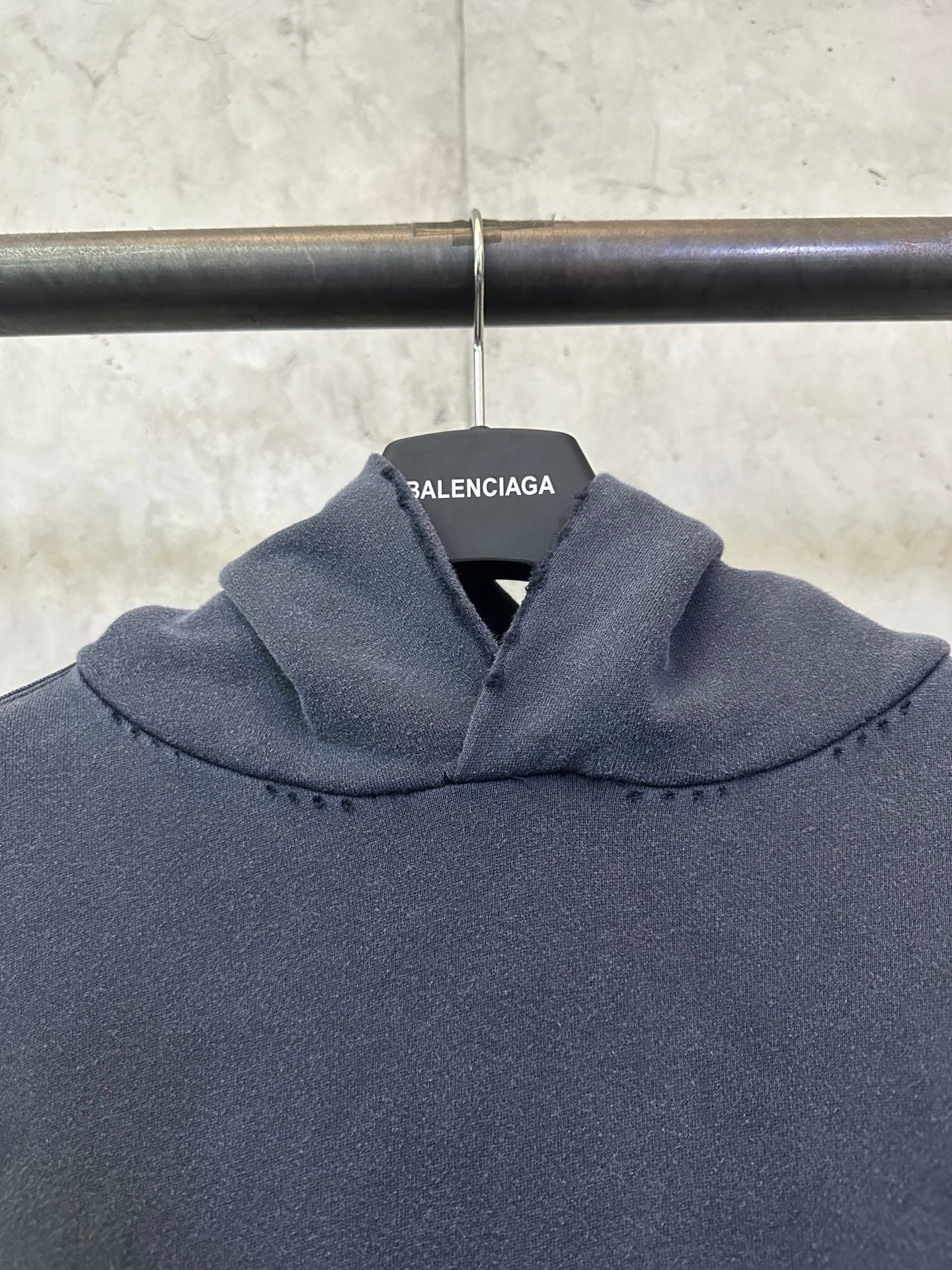 Balenciaga long-sleeve hoodie, dark gray, close-up of hood with brand label