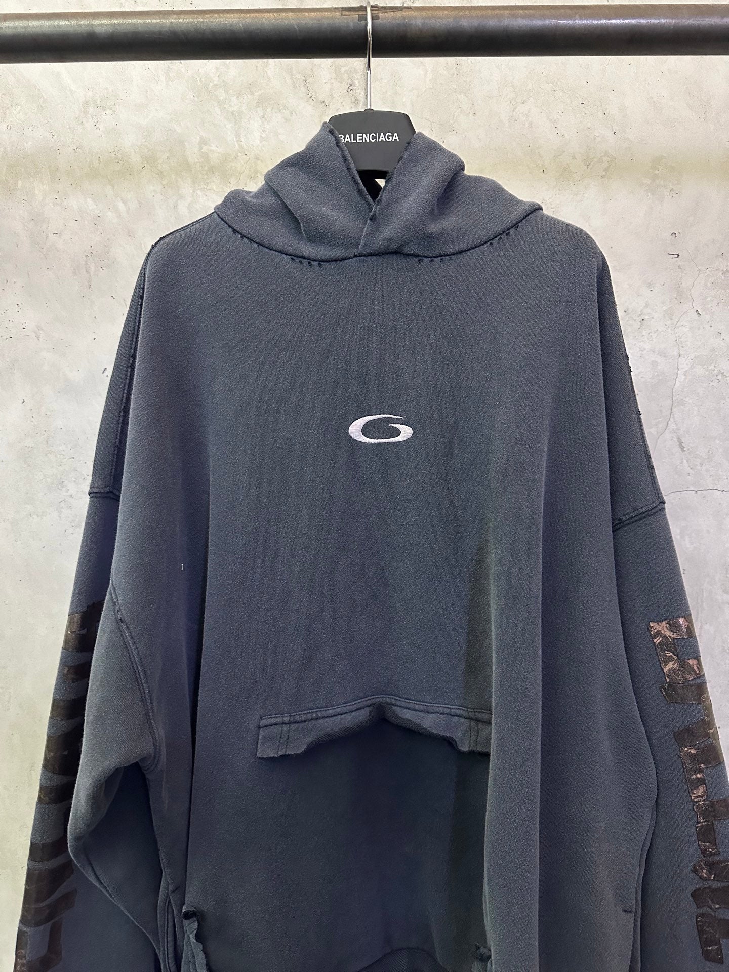 Balenciaga long-sleeve hoodie, dark gray, close front view with oval chest logo