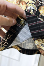 Black shirt fabric underside close-up showing inner lining and stitching