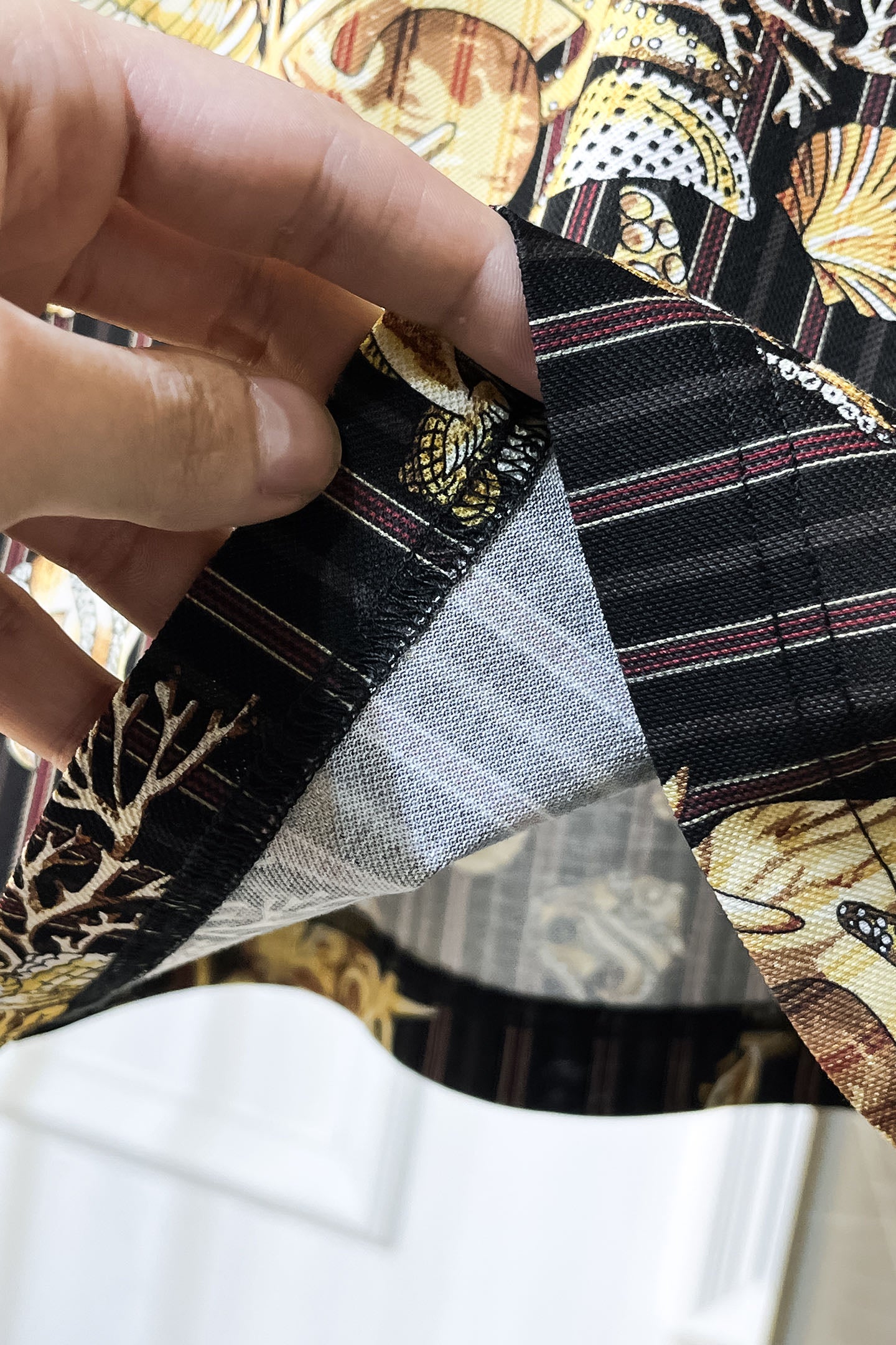 Black shirt fabric underside close-up showing inner lining and stitching