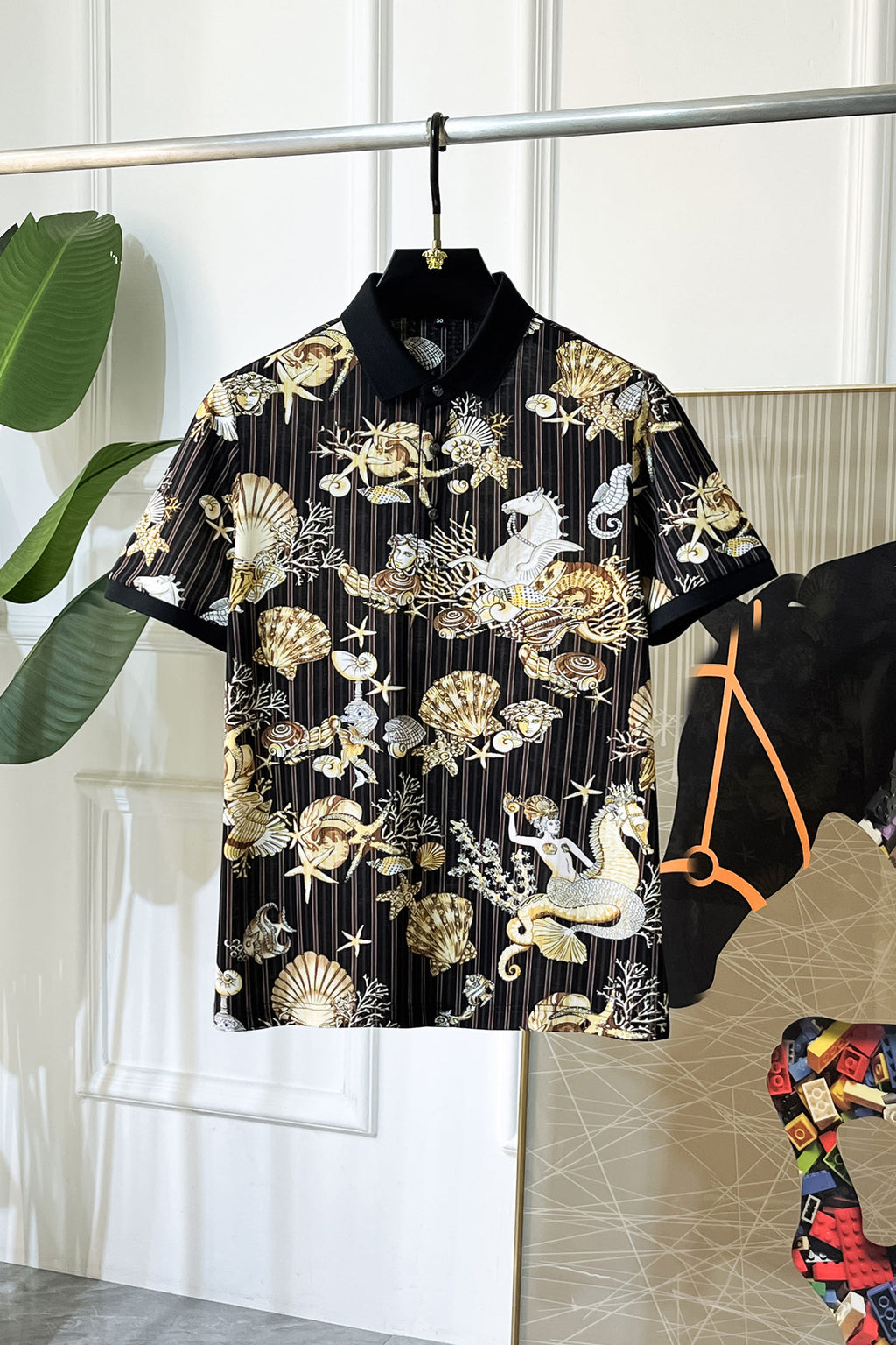 Black button-up shirt with gold, shell, and animal graphic print, short sleeves
