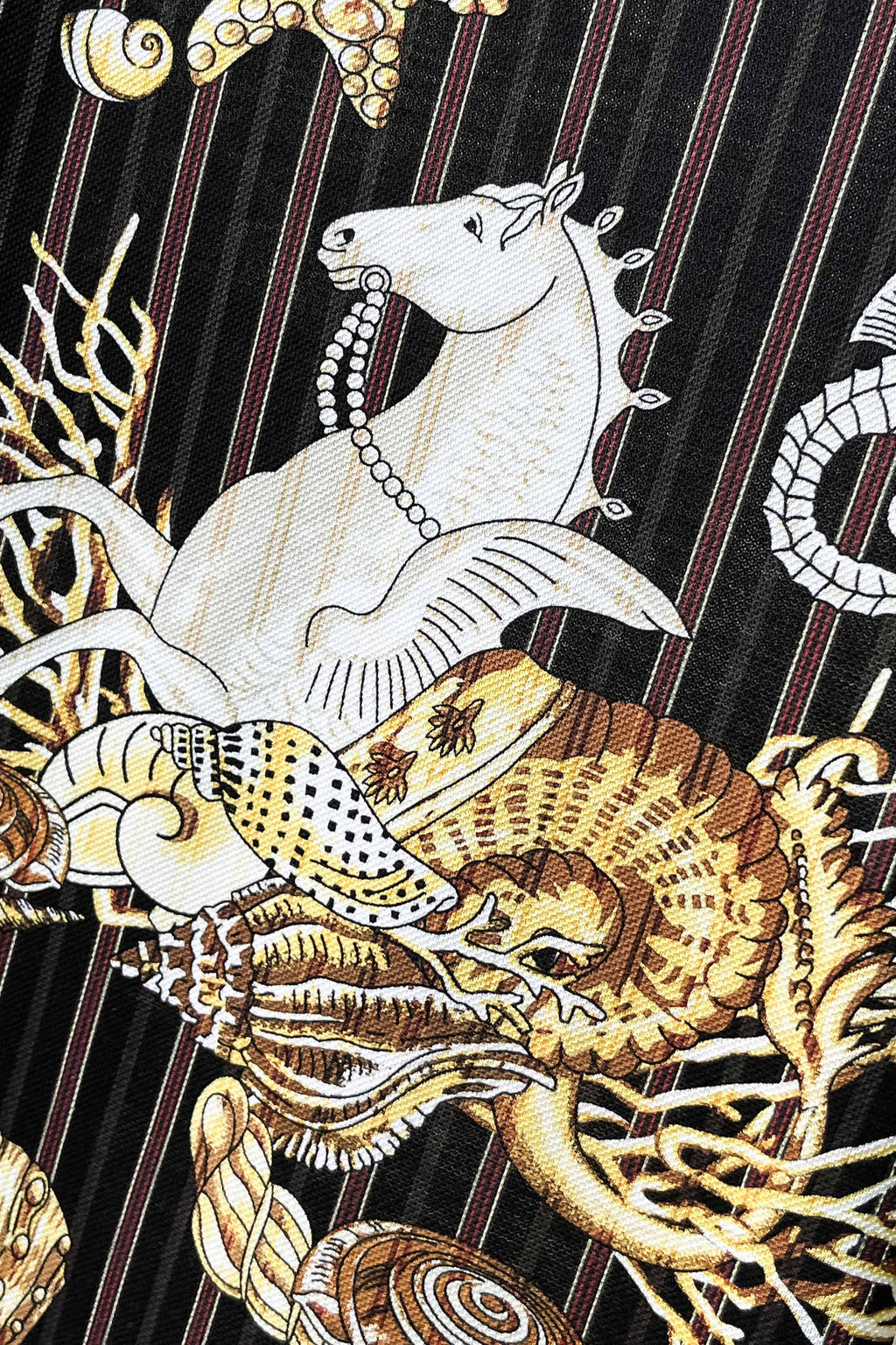 Black shirt front close-up with white animal and gold shell graphic print