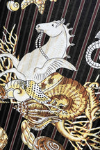 Black shirt front close-up with white animal and gold shell graphic print