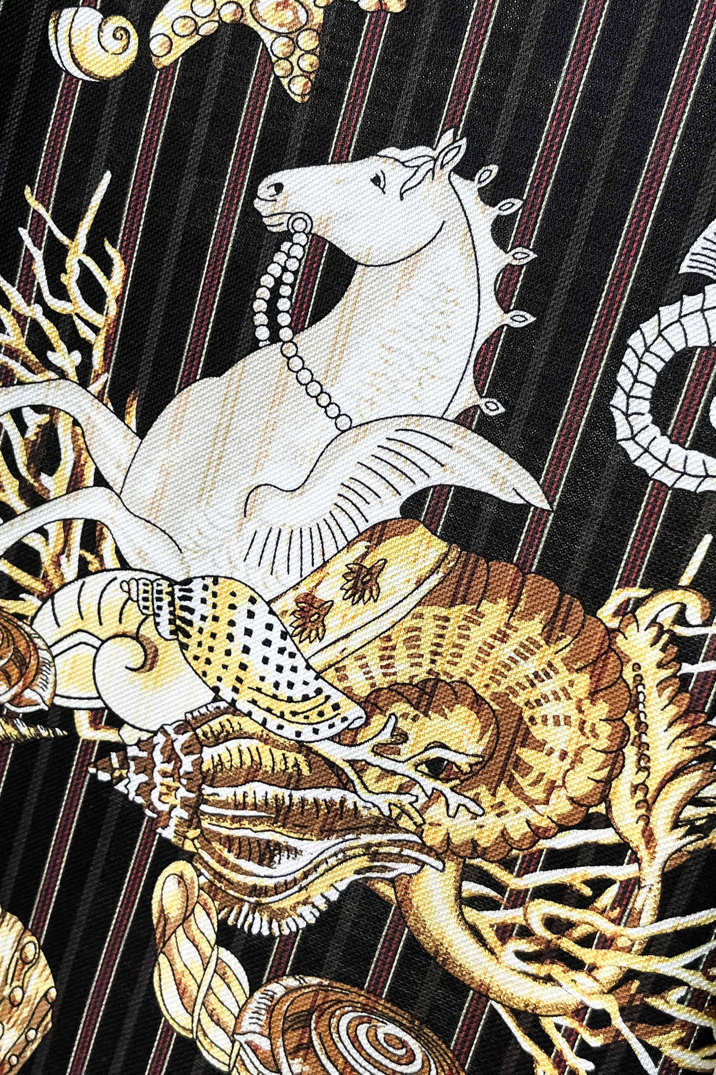 Black shirt front close-up with white animal and gold shell graphic print