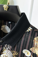 Black button-up shirt sleeve close-up with textured fabric and seashell graphic print