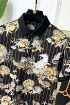 Black button-up shirt close-up with gold and white baroque shell and bird graphic