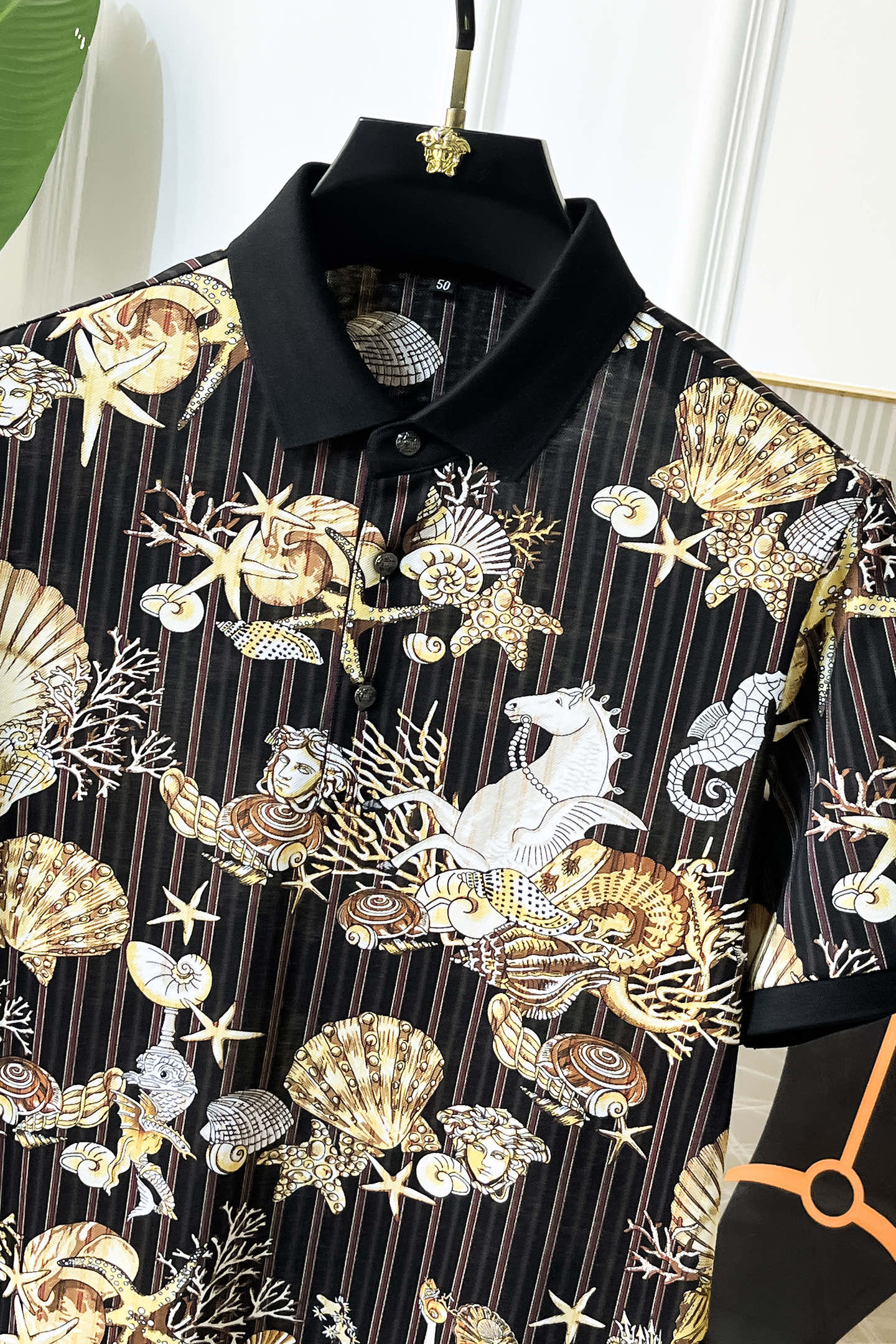 Black button-up shirt close-up with gold and white baroque shell and bird graphic