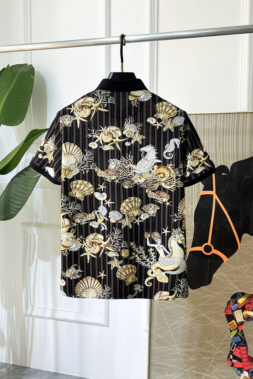 Black button-up shirt back view with gold and white shell and animal graphic print