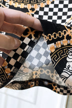 Versace shirt seam and cuff detail with black-and-white checker panel and gold chain trim