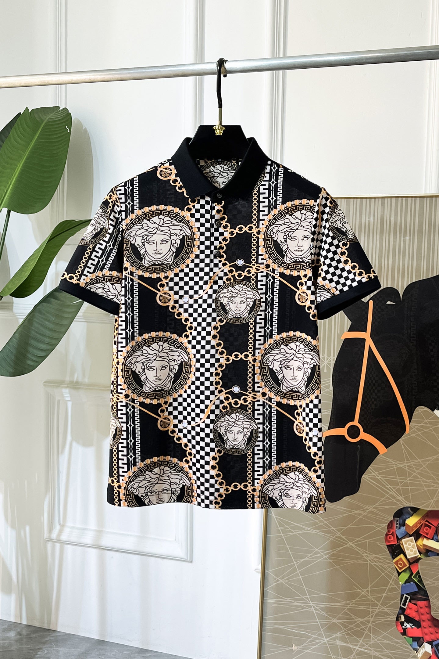 Versace shirt with black base, checker pattern, gold chain trim, and Medusa medallions