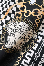 Versace fabric close-up: black-and-white checker print with Medusa bust emblem and gold trim