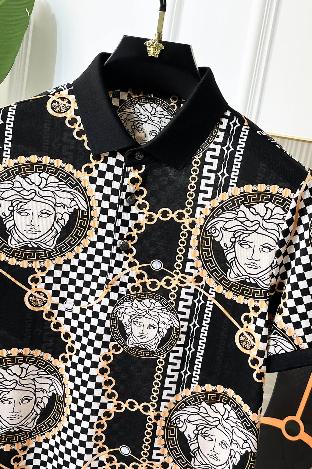 Versace printed shirt neckline with black collar and gold-chain detailing around medallions