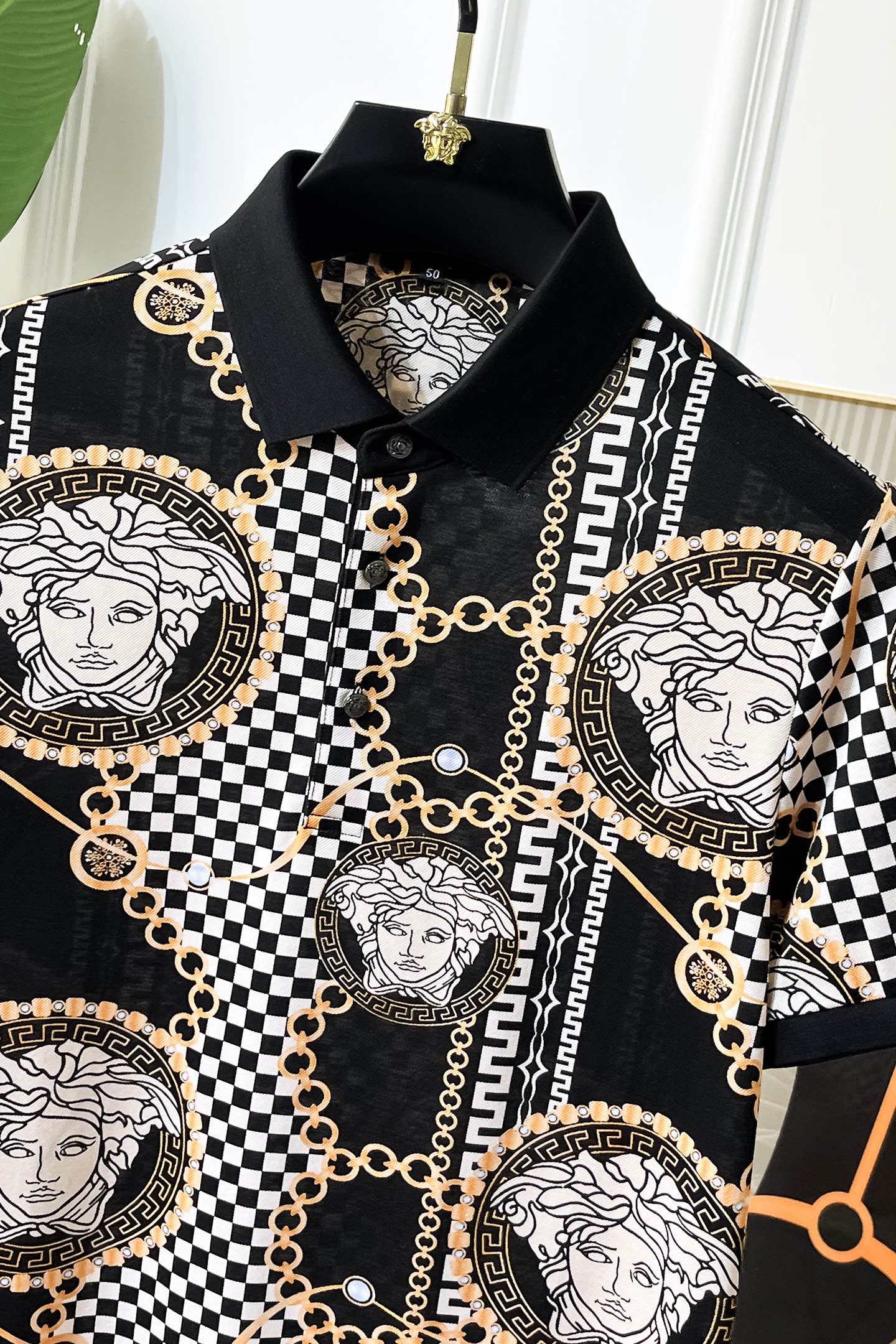 Versace printed shirt neckline with black collar and gold-chain detailing around medallions