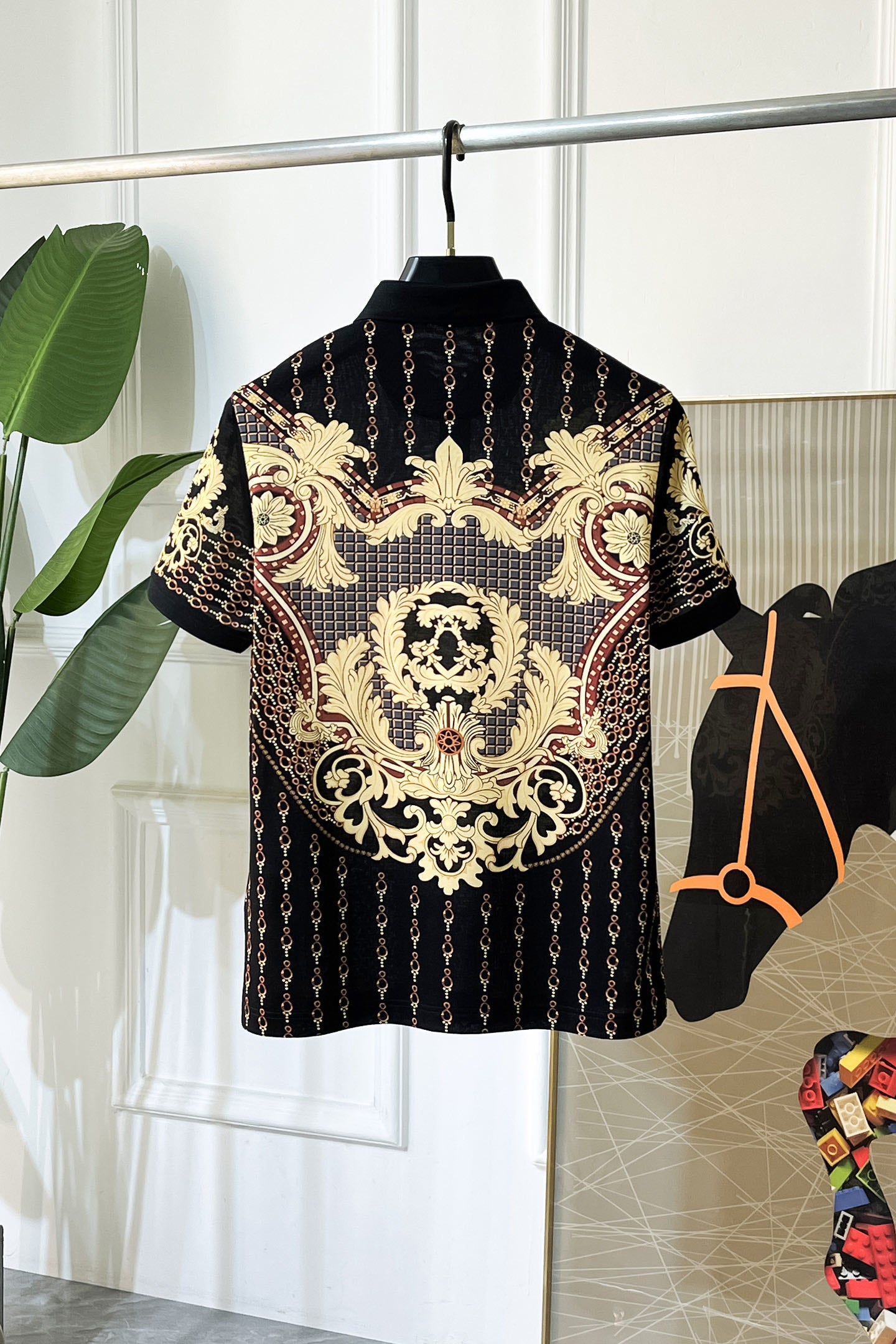 Black Versace polo shirt with gold baroque medallion and chain details