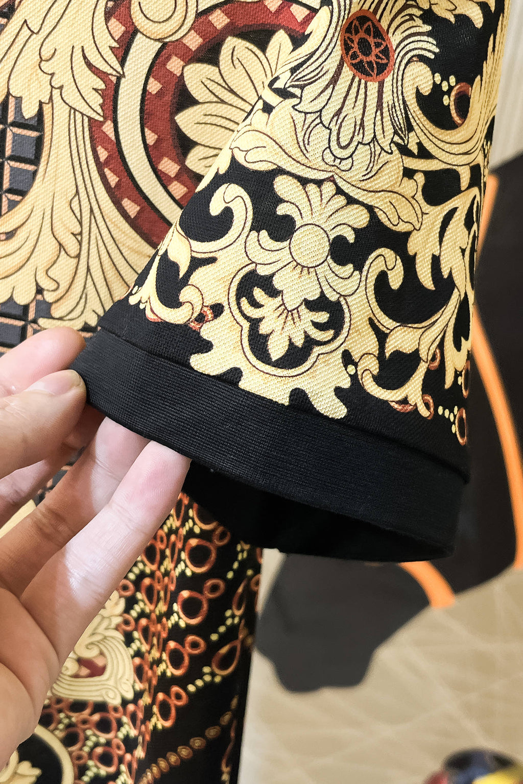 Versace polo shirt hem detail with gold baroque floral print