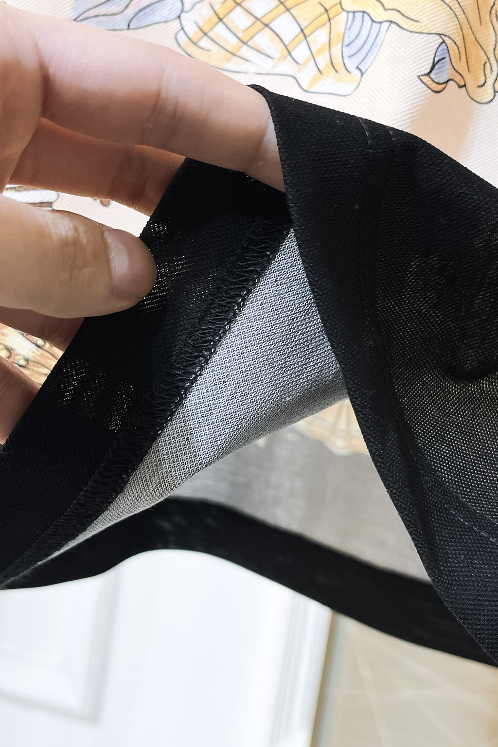 Versace polo shirt fabric close-up showing black textured weave and printed trim