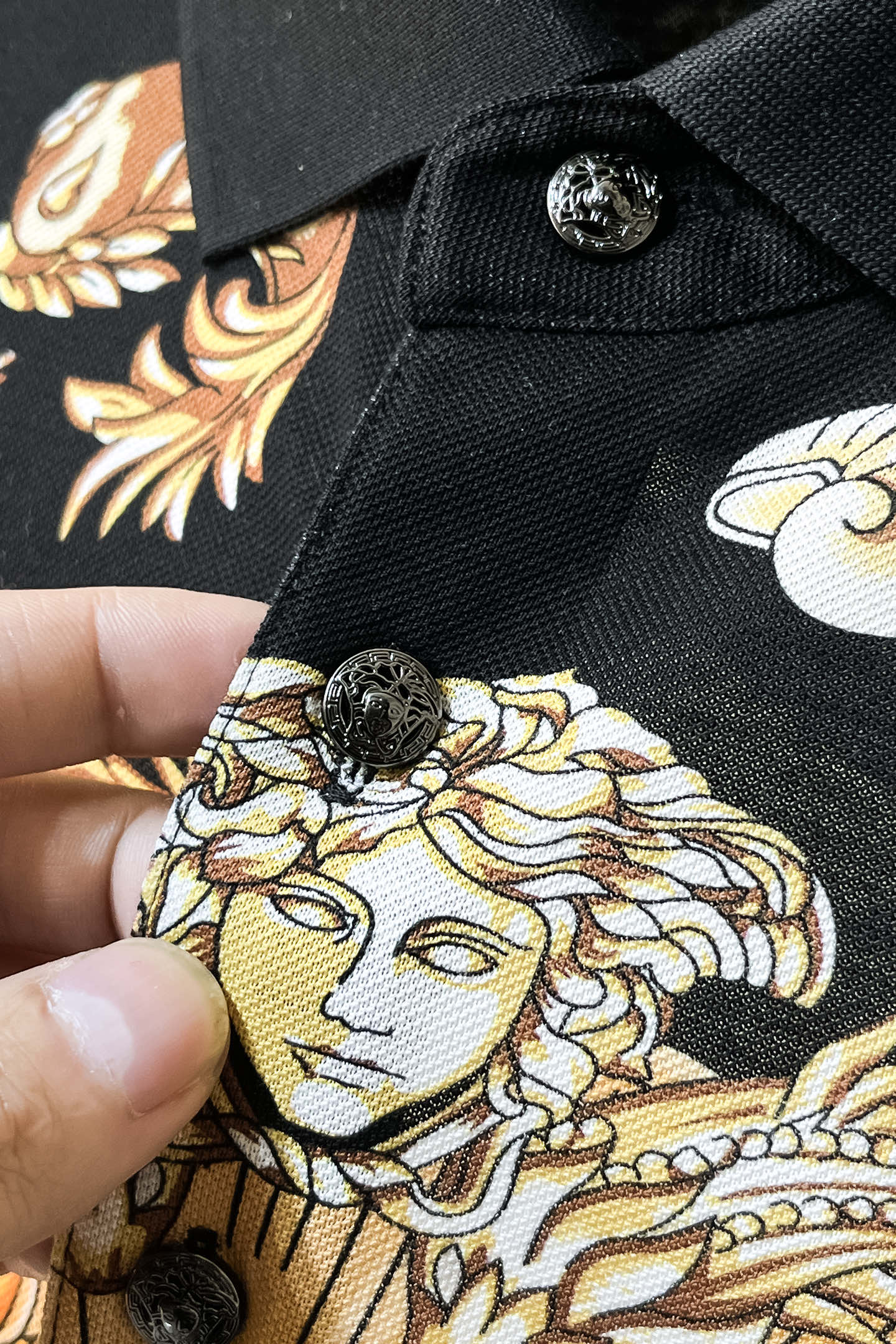 Versace polo shirt button placket with black buttons and baroque gold, cream print